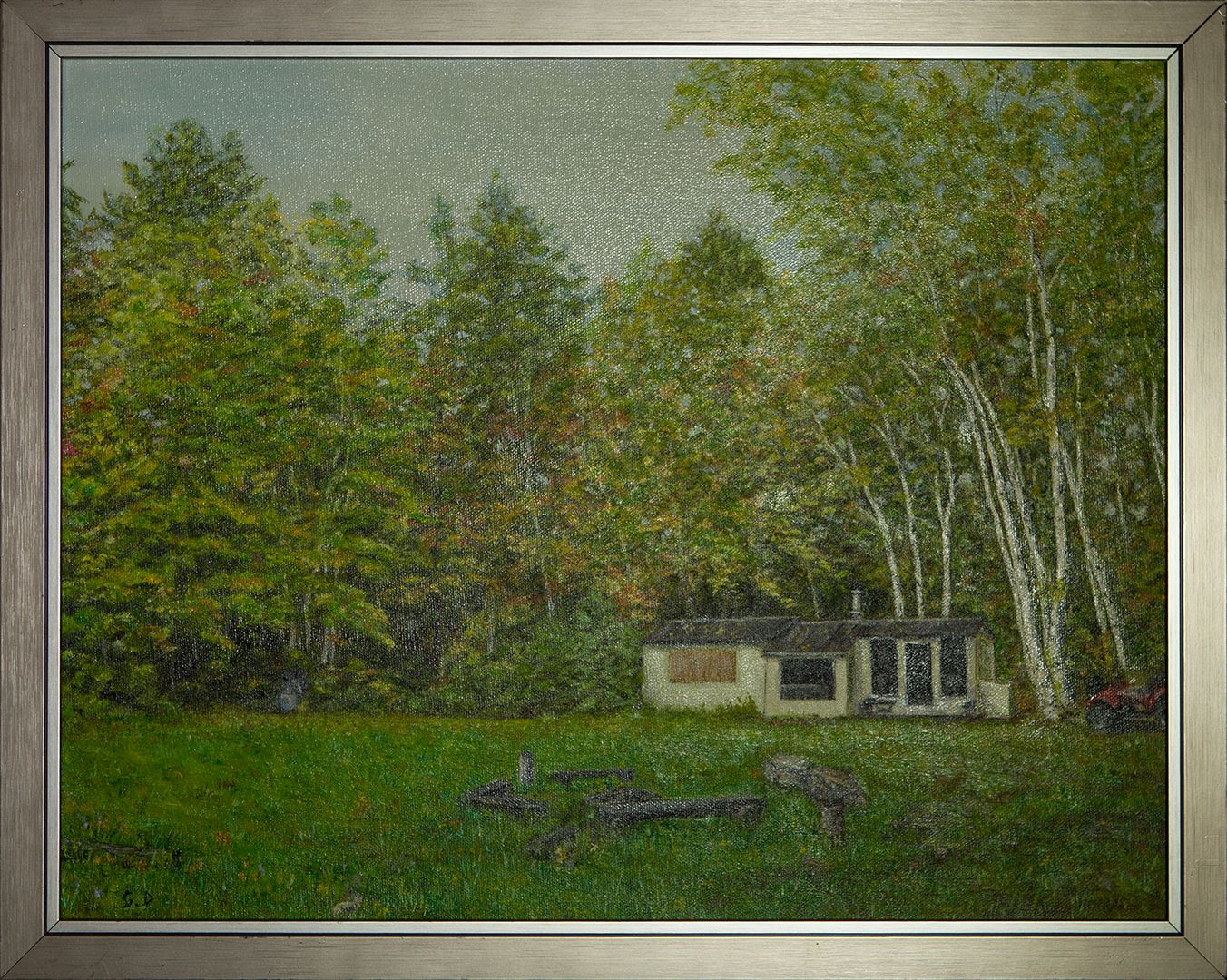 A small white cabin at the edge of a forest of tall birches and pines, with a lawn and a fire pit ringed by logs in front.
