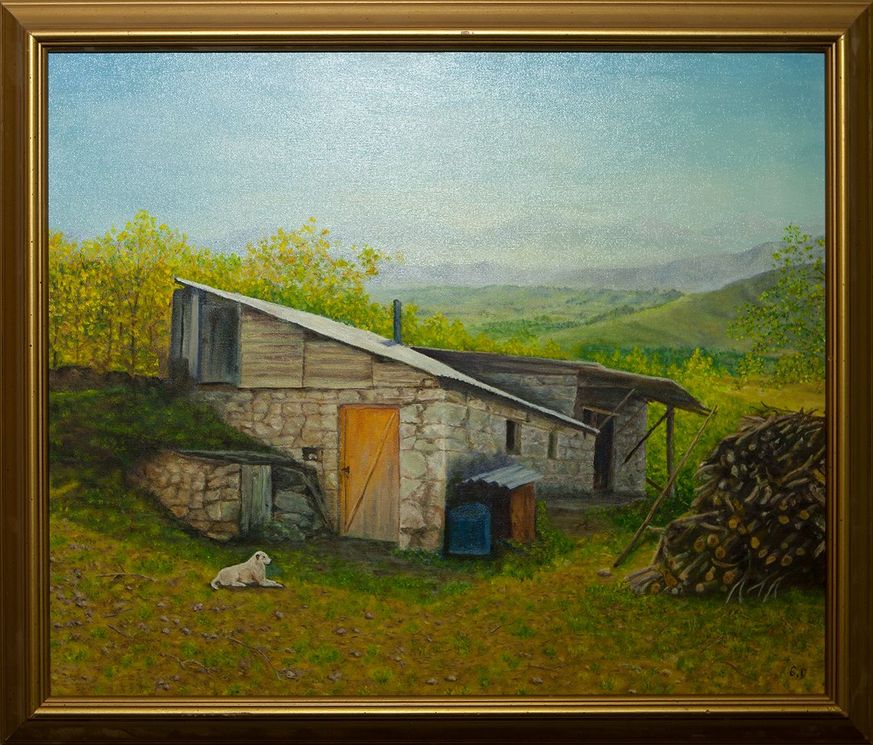 An old stone barn with a wooden door and a slanted roof on a hillside, a stacked woodpile beside it and a pale dog lying on the grass, with green hills behind.